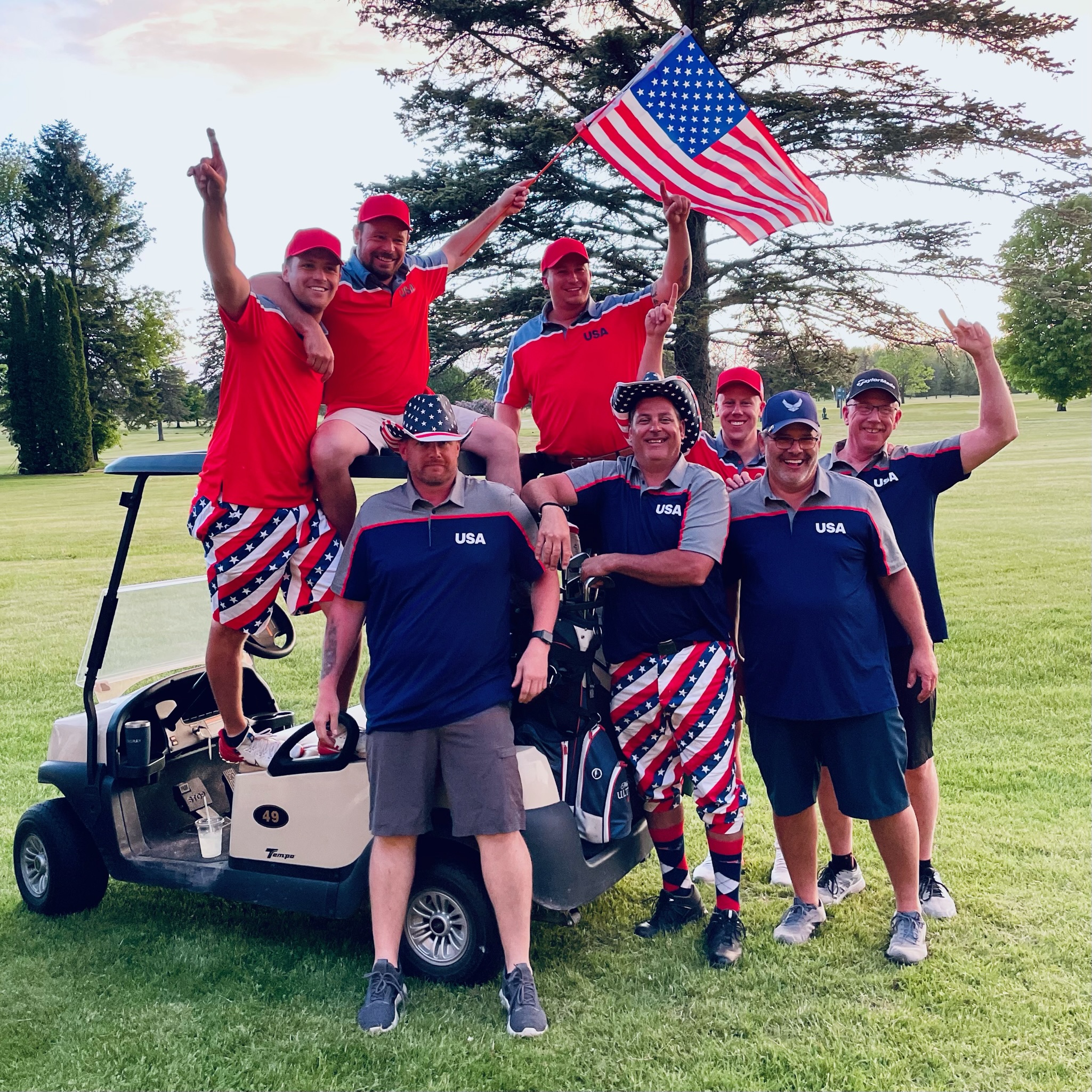 Team Jake celebrating around the golf cart with the American flag after winning the 2022 Ryder Cup