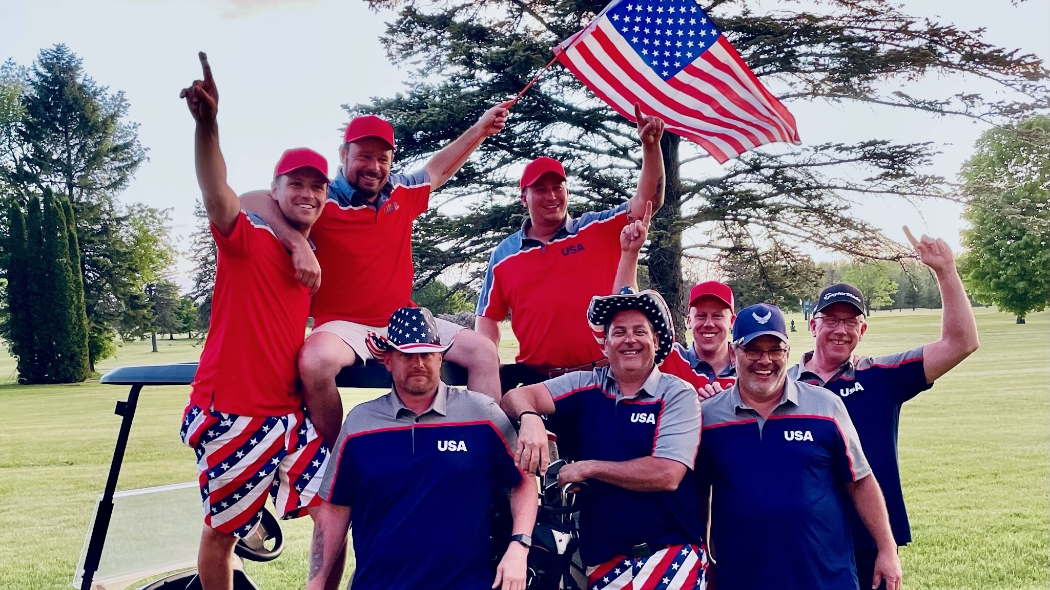 Team Jake celebrating the 2022 Ryder Cup win around a golf cart with an American flag